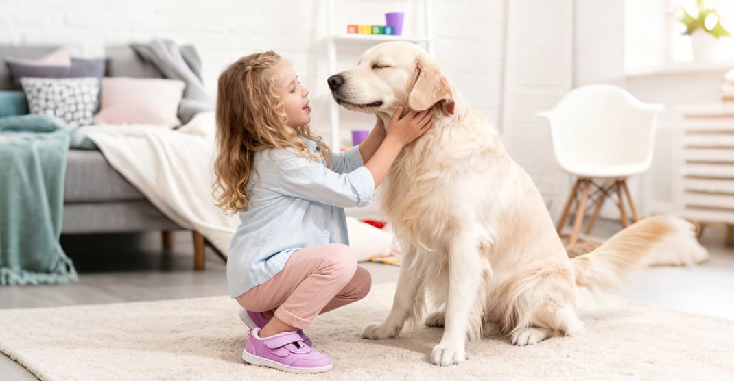 Blog - A little girl cuddling her dog on the carpet, representing love, bonding, and pet lifestyle inspiration from Sovelivee.