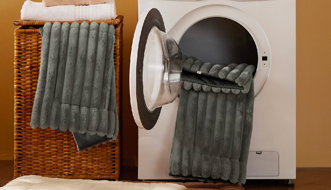 Grey self heating cat bed being placed in a washing machine, highlighting its durable, machine-washable design for easy cleaning against odors and hair.